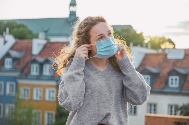 Young woman putting on a face mask