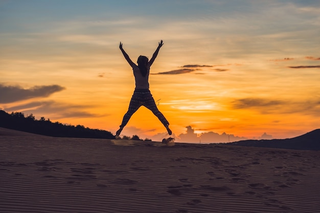 Young woman in rad sandy desert at sunset or dawn