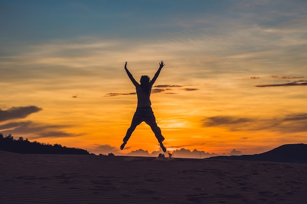 Young woman in rad sandy desert at sunset