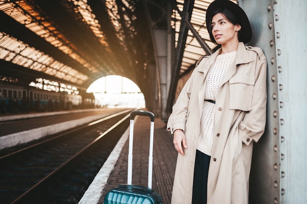 Young woman at the railway station awaits the arrival of the train