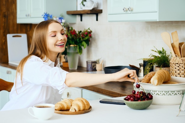 Young woman reaches for a cherry