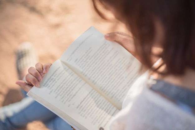 A young woman reading a book. Book in woman hands