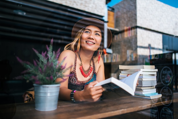 Young woman  reading book and fresh cup of coffee on the table