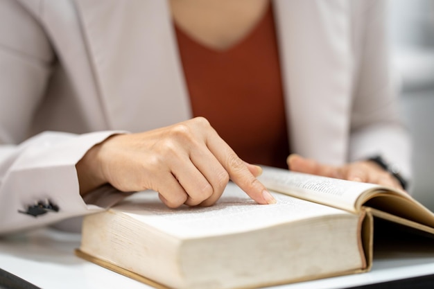 Young woman reading a book in library at university