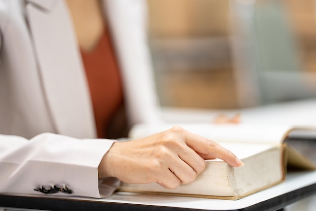 Young woman reading a book in library at university