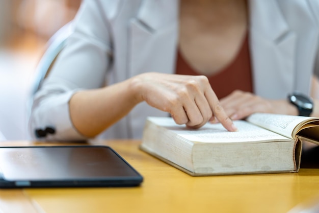 Young woman reading a book in library at university