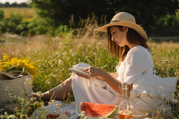 Young woman reading book in outdoor field reading and relaxation