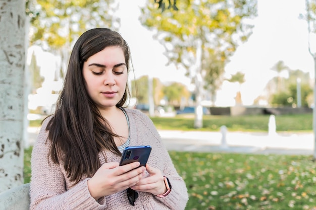 Young woman reading message at park