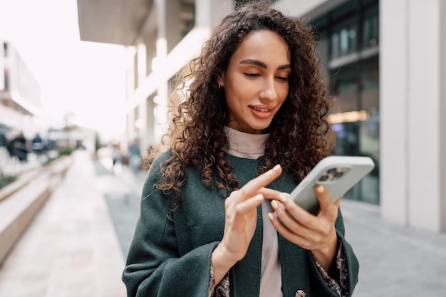 Young woman reading a message or using the phone in the city