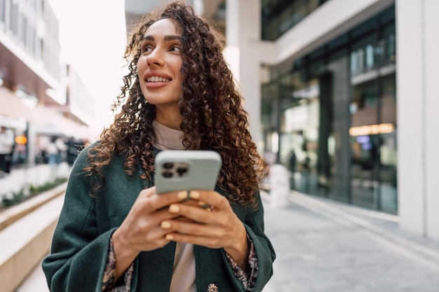 Young woman reading a message or using the phone in the city