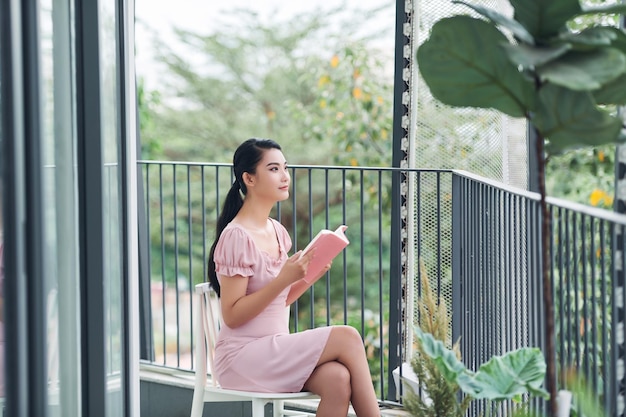 Young woman reads a book at balcony