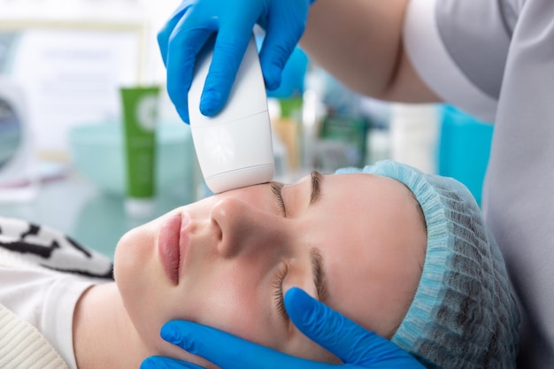 Young woman receiving electric galvanic antiaging face spa massage at beauty salon