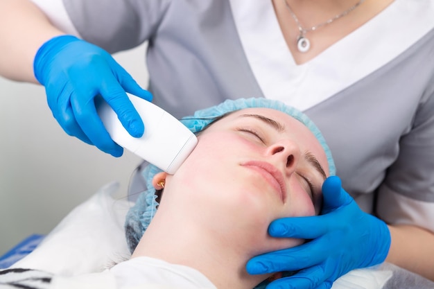 Young woman receiving electric galvanic antiaging face spa massage at beauty salon