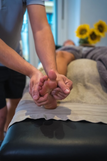 A young woman receiving a foot massage from a physical therapist. Physio, osteopathy