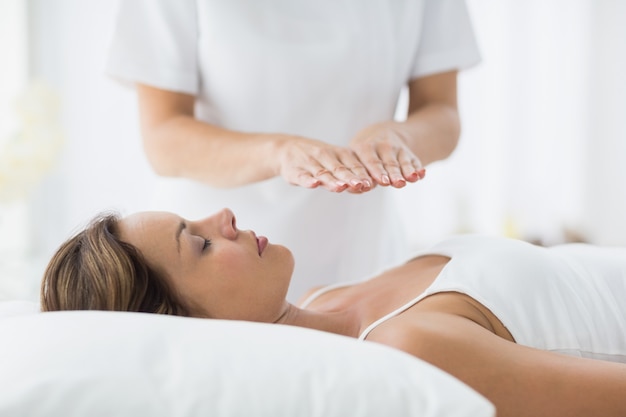 Young woman receiving reiki treatment