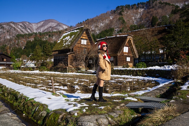 Young Woman in a Red Cap with the Heritage Wooden Farmhouse Background.