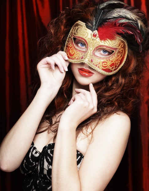 Young woman in a red mysterious mask