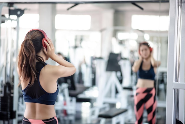 Photo young woman reflecting on mirror at gym