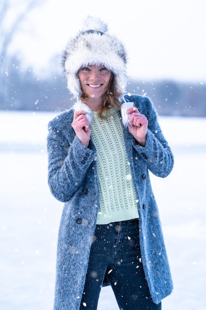 Young woman rejoices the first snow in winter