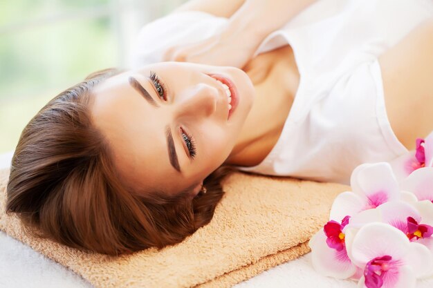 Young woman on rejuvenating facial massage in beauty studio