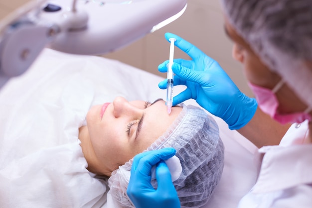 Young woman on rejuvenation procedure in a cosmetology clinic.