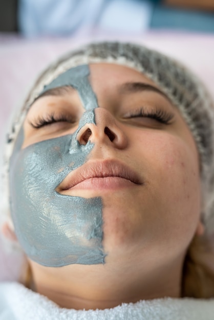 Young woman relaxes in a beauty spa after applying a mask on her face. Healthcare concept