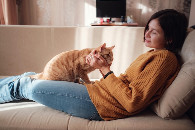 Young woman resting with pet in sofa at home