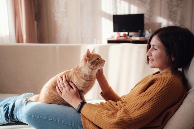 Young woman resting with pet in sofa at home