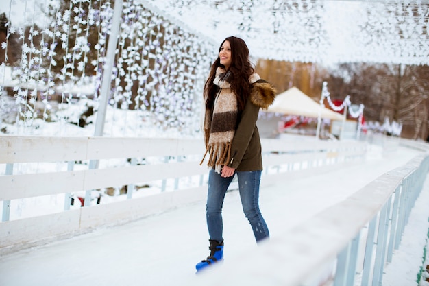 Young woman rides ice skates in the park