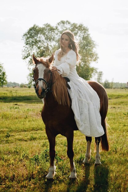 Photo young woman riding horse on field