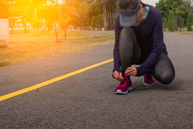 Young woman runner tying shoelaces