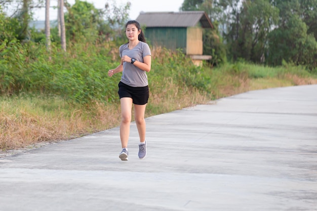 Young woman running during sunny morning on stadium track