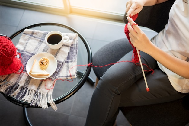 young woman’s hands knitting warm sweaters