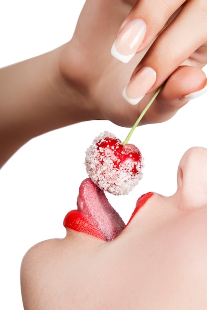 Young woman's mouth with red cherry covered with sugar