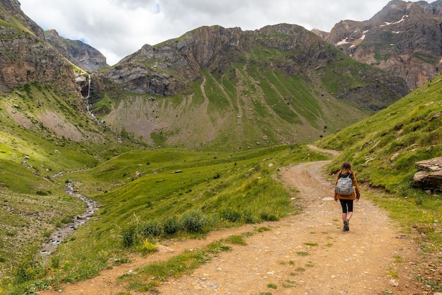 A young woman next to the Salto de Tendenera Waterfall in the Ripera Valley Panticosa Pyrenees