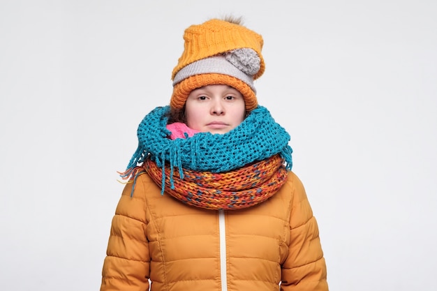 Young woman in several hats and scarfs