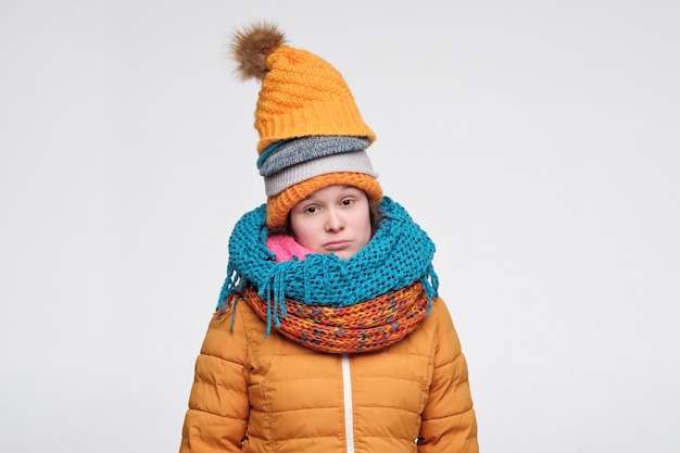 Young woman in several hats and scarfs