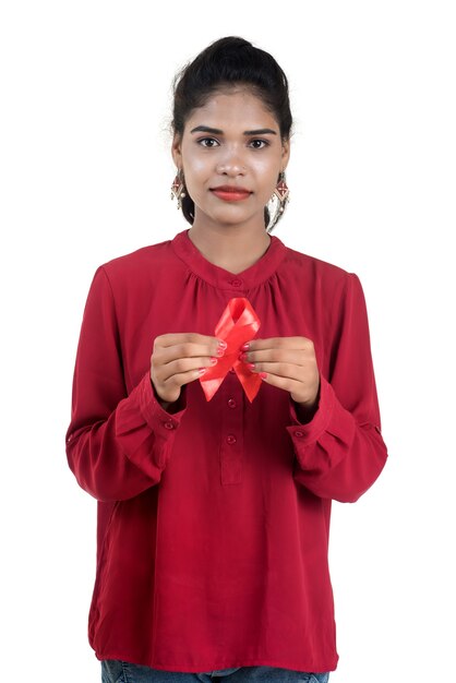 Young woman showing red ribbon HIV, AIDS awareness ribbon, healthcare and medicine concept