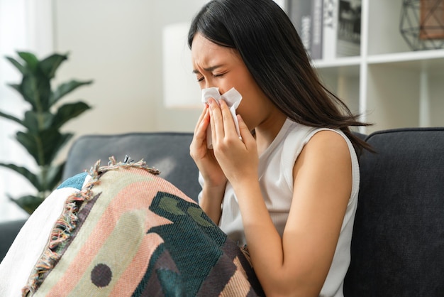 Young woman sick on the sofa with use paper napkin the mouth, infections, flu.