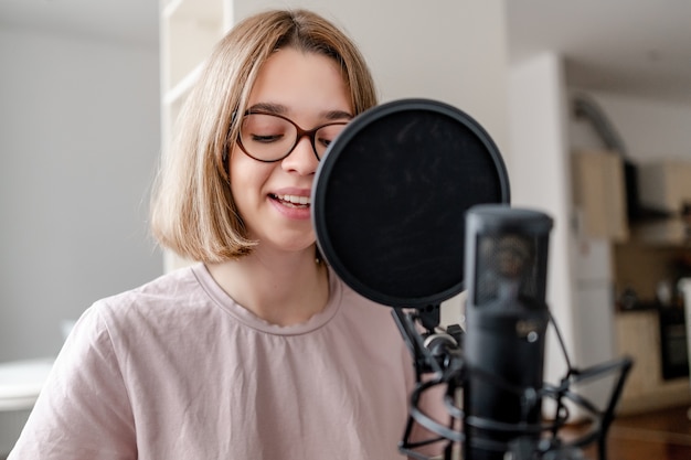 Young woman singing with microphone and smiling at home