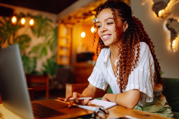 Young woman sitting at cafe making online shopping using credit card and laptop Online shopping