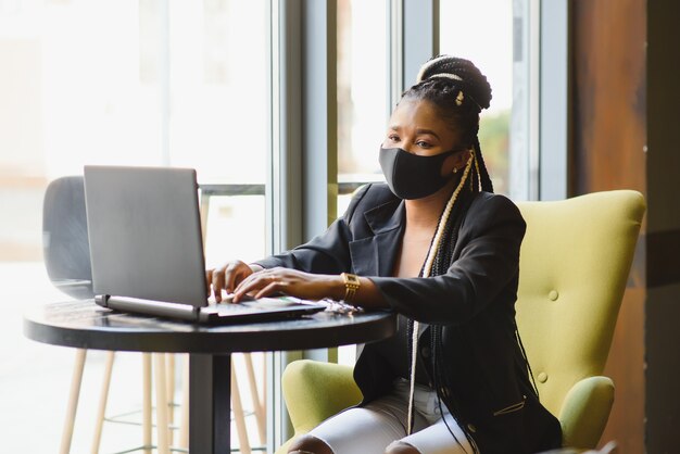 Young woman sitting in a cafe working on a laptop