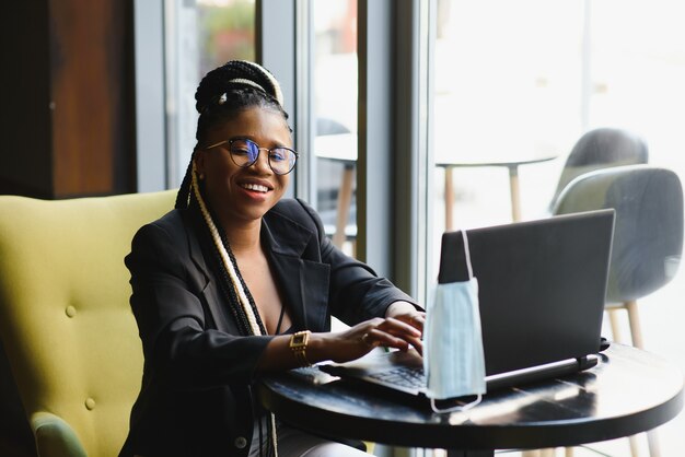 Young woman sitting in a cafe working on a laptop