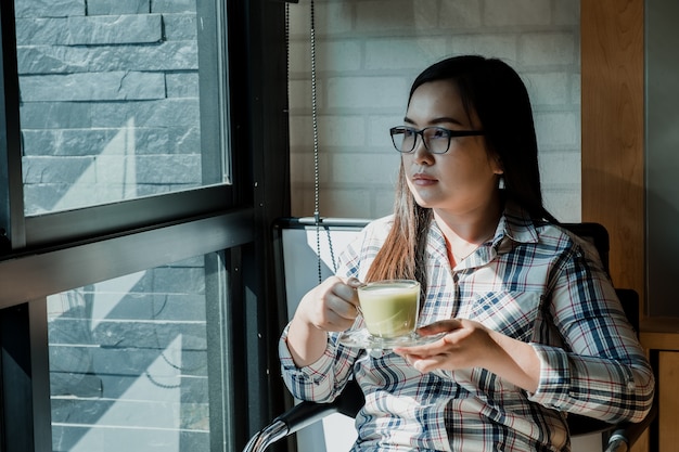 Young woman sitting in coffee shop and drinking coffee.