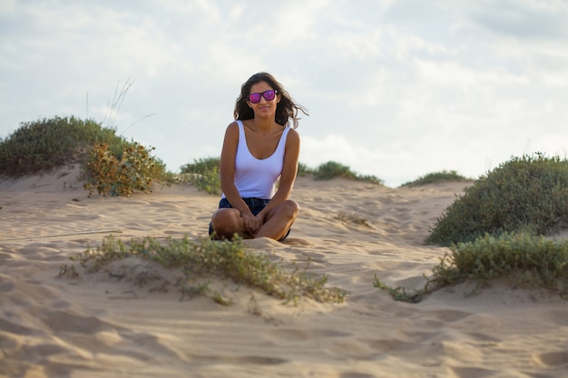 Young woman sitting on the dunes