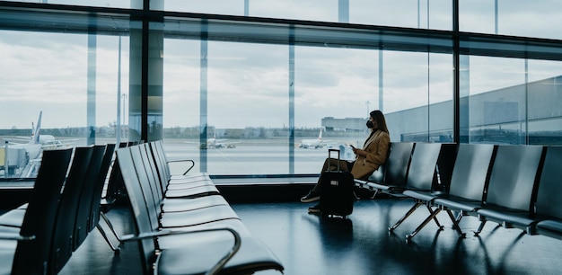 Young woman sitting at the empty airport hall Waiting for flight Cover photo