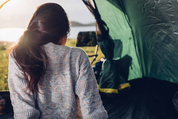 Young woman sitting looking out camping tent on travel outdoor holiday summer