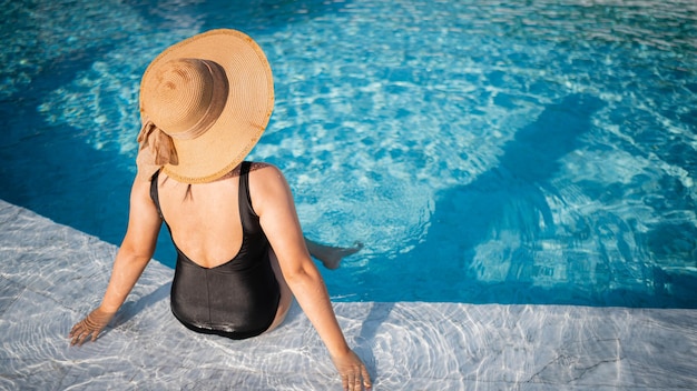 Young woman sitting in the pool in luxury resort