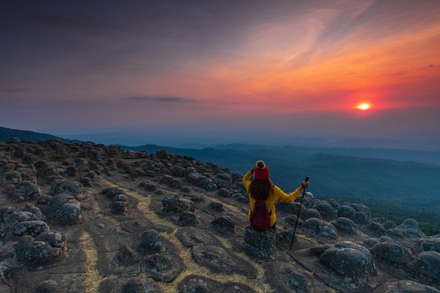 Young woman sitting on a rock in the mountains