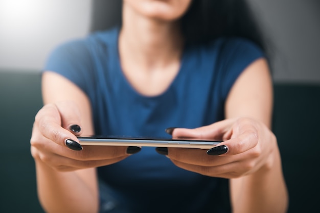 Young woman sitting at the table with the phone